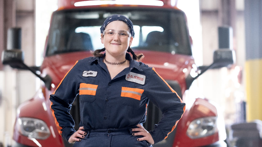 young driver front of truck in garage