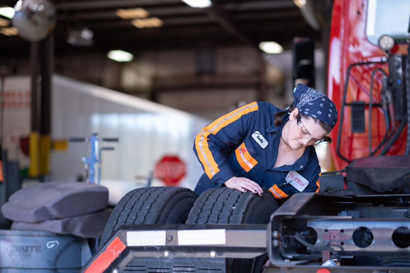 worker-checking-tires-in-shop